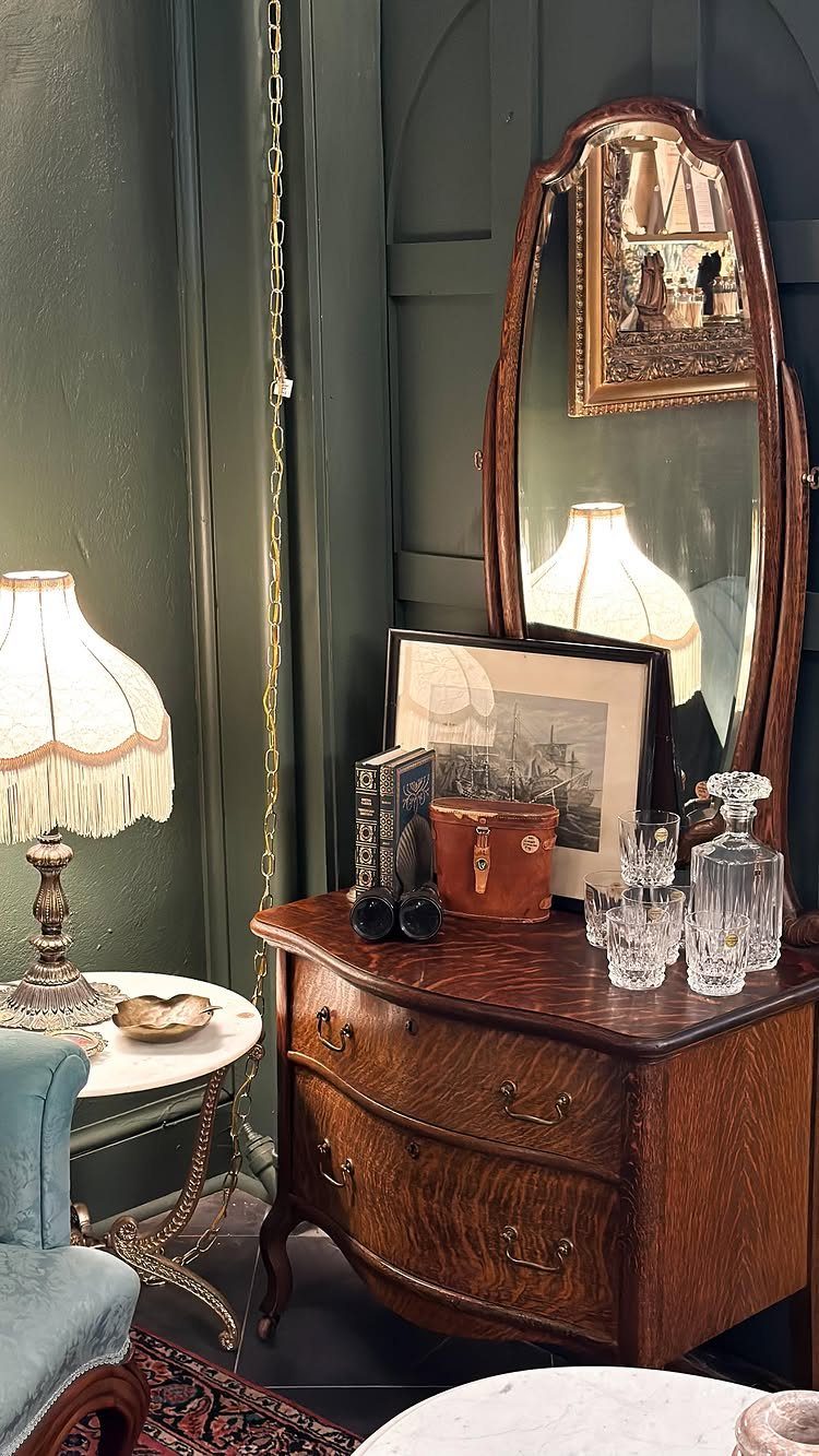 9 Old Money Dining Room Ideas for Timeless Elegance 6 Wooden sideboard with crystal glasses and a large mirror in a green room.