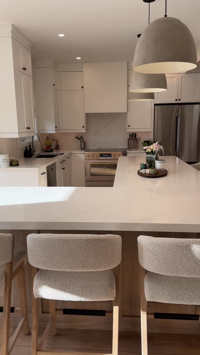 13 Open Concept Dining Room Ideas with Photos 3 White kitchen island with grey fabric bar stools and large dome pendant lights