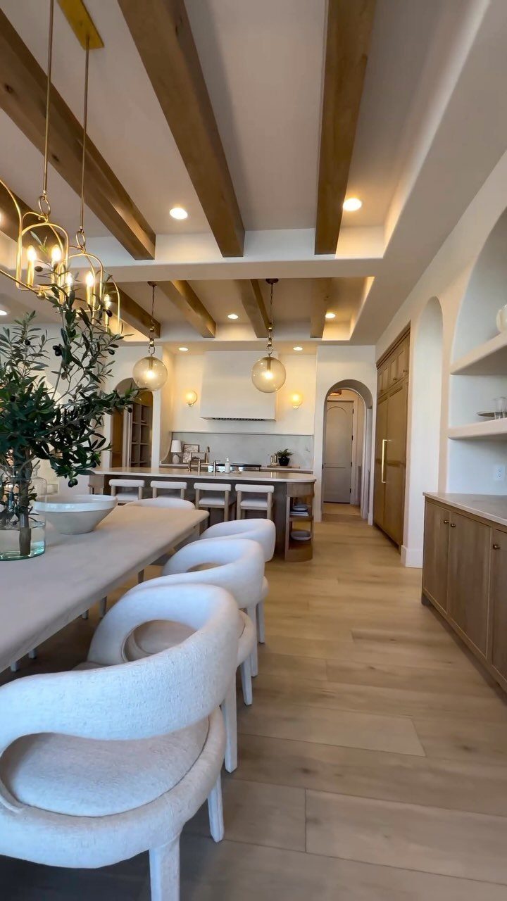 13 Open Concept Dining Room Ideas with Photos 5 Modern open concept dining room and kitchen with wooden ceiling beams and white chairs.