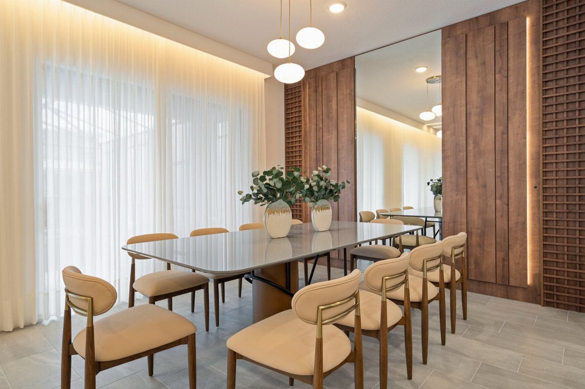13 Open Concept Dining Room Ideas with Photos 10 Modern dining room with a long grey table, beige chairs, and wood-paneled walls.