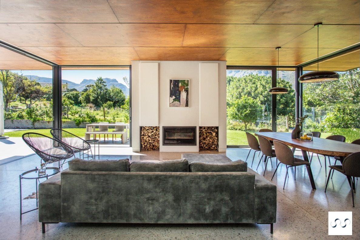 Polished concrete flooring extending through a modern open living and dining room area.