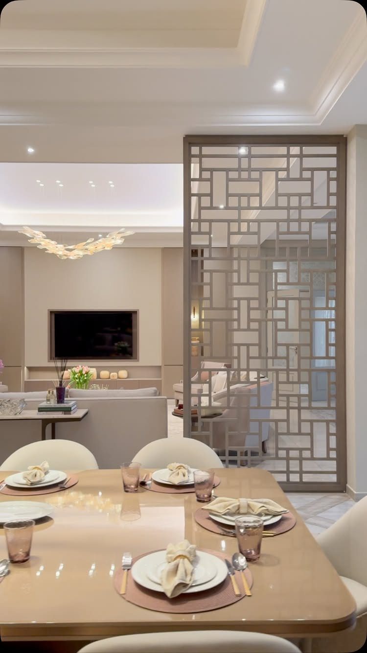 Dining table set for four next to a geometric screen dividing the living room