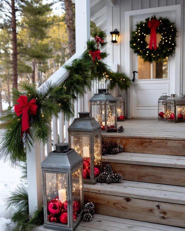 4 Outdoor Railing Christmas Decorations for Your Porch 1 Green pine garland with red bows and lights decorating a white porch railing.