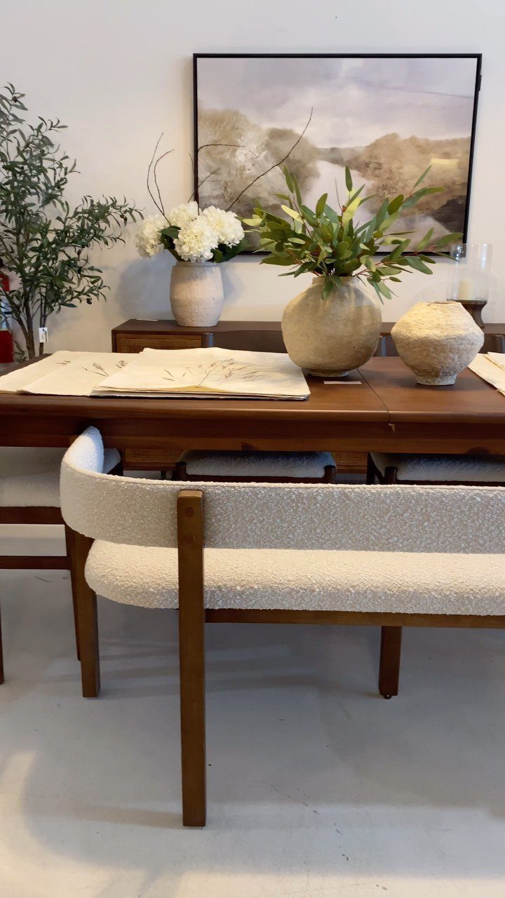 11 Rustic Modern Dining Room Ideas with Real Character 9 Wooden dining table with white bouclé bench and ceramic vases with greenery