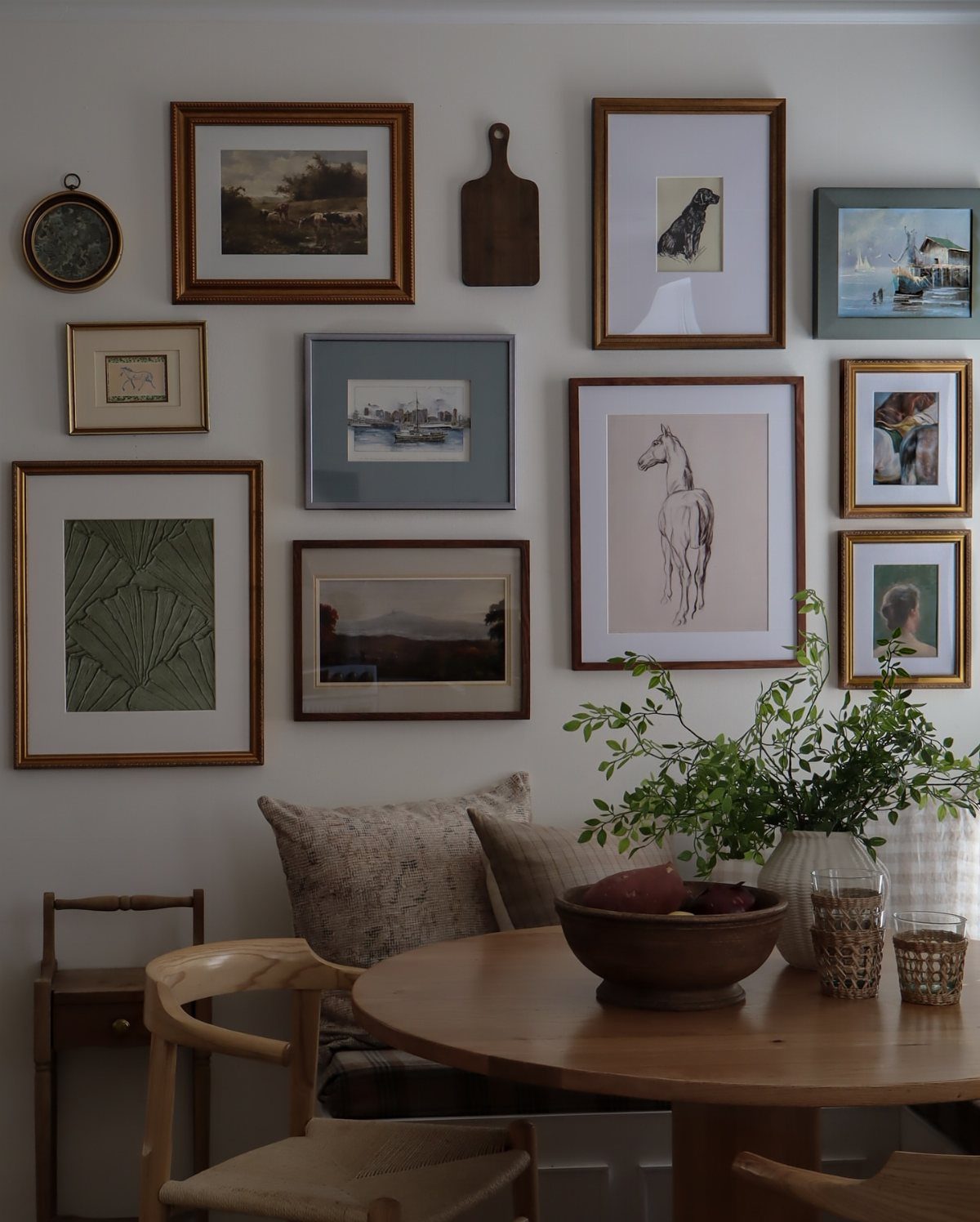15 Small Breakfast Room Ideas for Cozy Spaces 10 Gallery wall with framed art and a wooden board above a breakfast table.