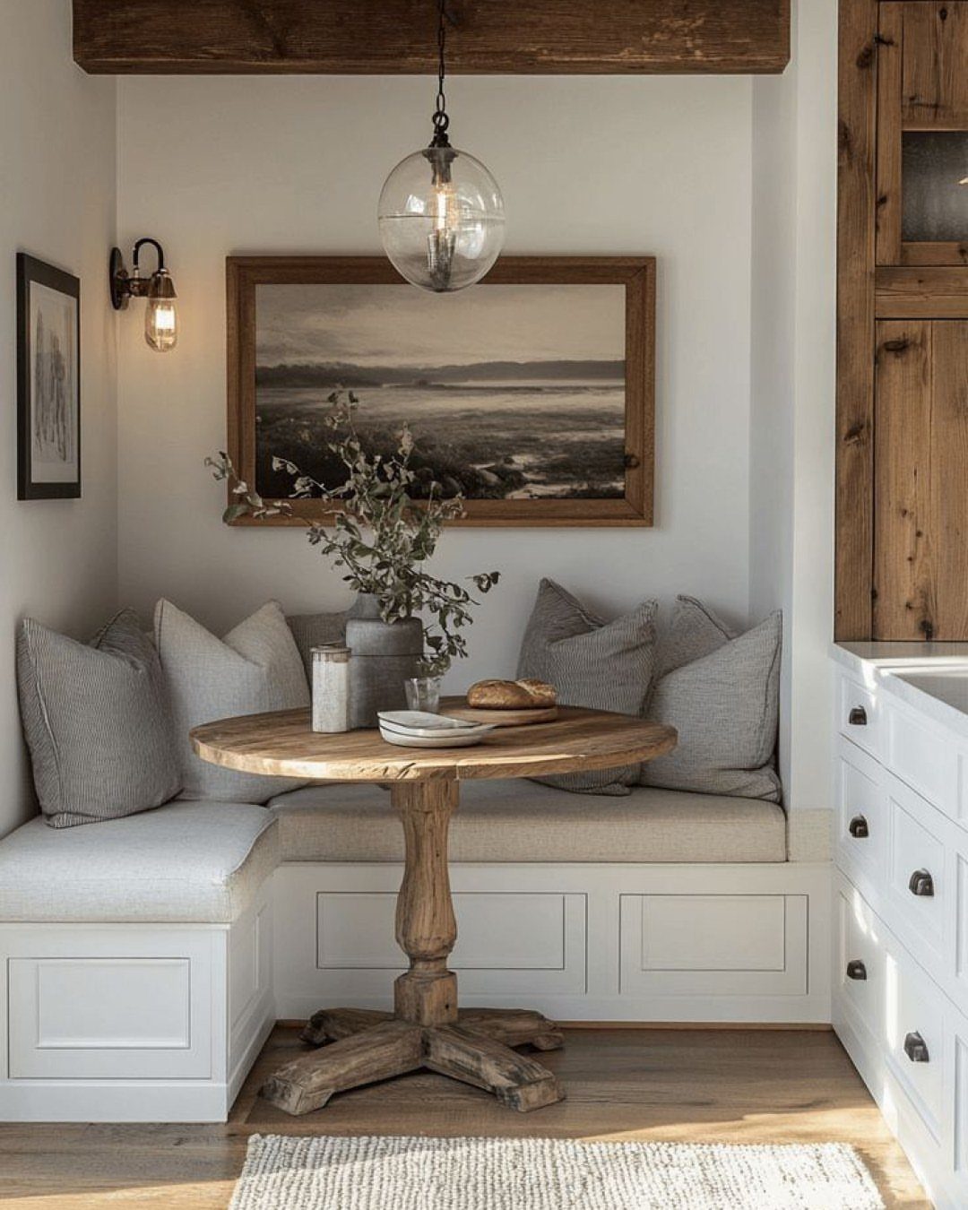 15 Small Breakfast Room Ideas for Cozy Spaces 11 L-shaped white built-in booth seating with a round wooden table in a cozy nook.