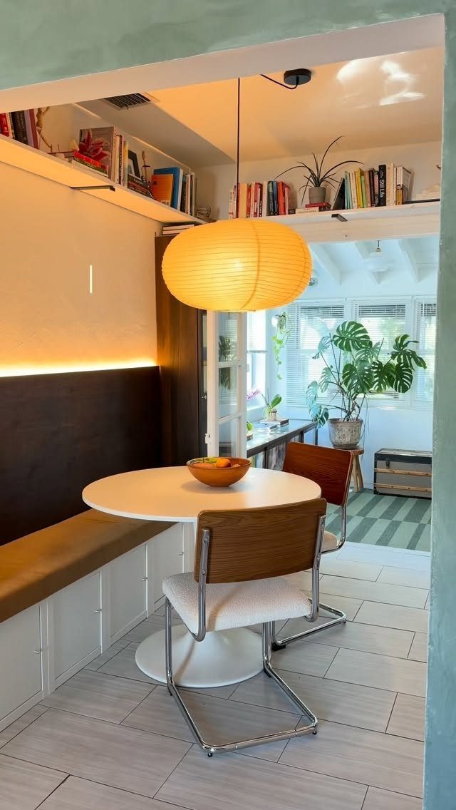 15 Small Breakfast Room Ideas for Cozy Spaces 3 Round white table with a built-in tan bench and modern chairs in a nook.