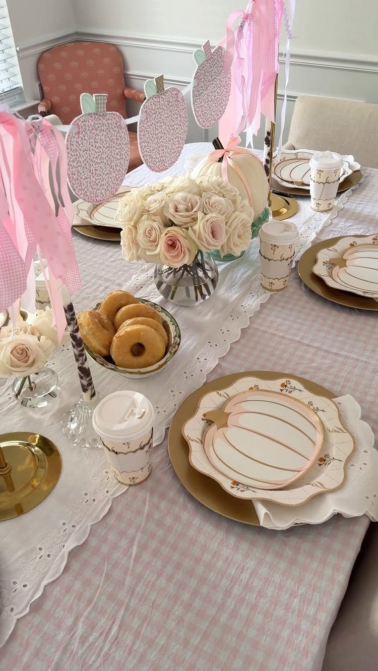 15 Small Breakfast Room Ideas for Cozy Spaces 2 Decorated table with pink gingham cloth, gold plates, white roses, and donuts.