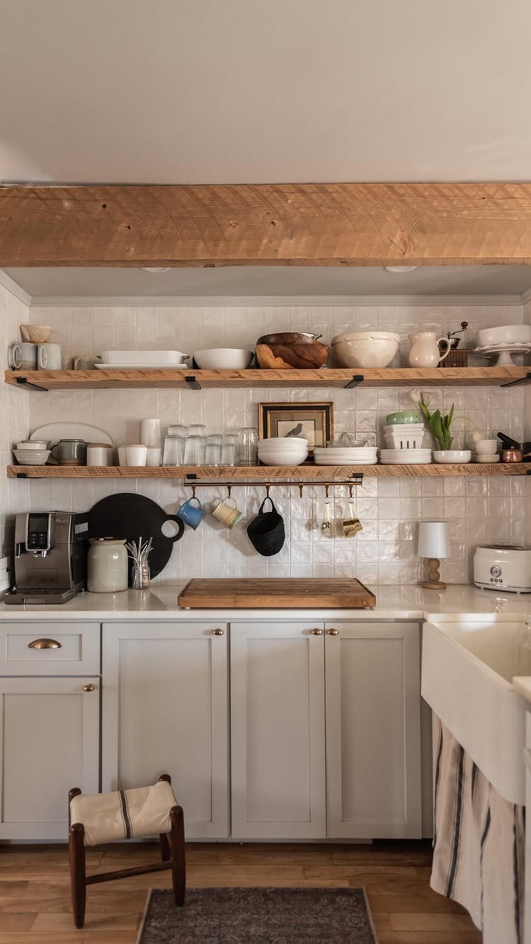 15 Small Breakfast Room Ideas for Cozy Spaces 13 White kitchen cabinets and open wooden shelves holding various ceramic bowls and glassware.