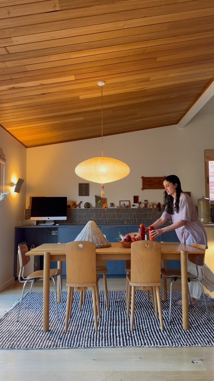 Woven blue and white rug under a light wood dining table and chairs.