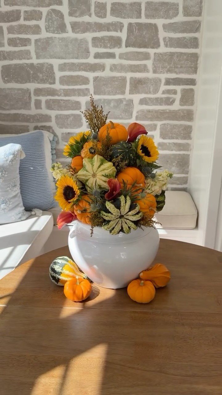 8 Small Dining Table Decor Ideas for Every Style 2 Miniature pumpkin and sunflower arrangement in a white bowl on a wooden table.