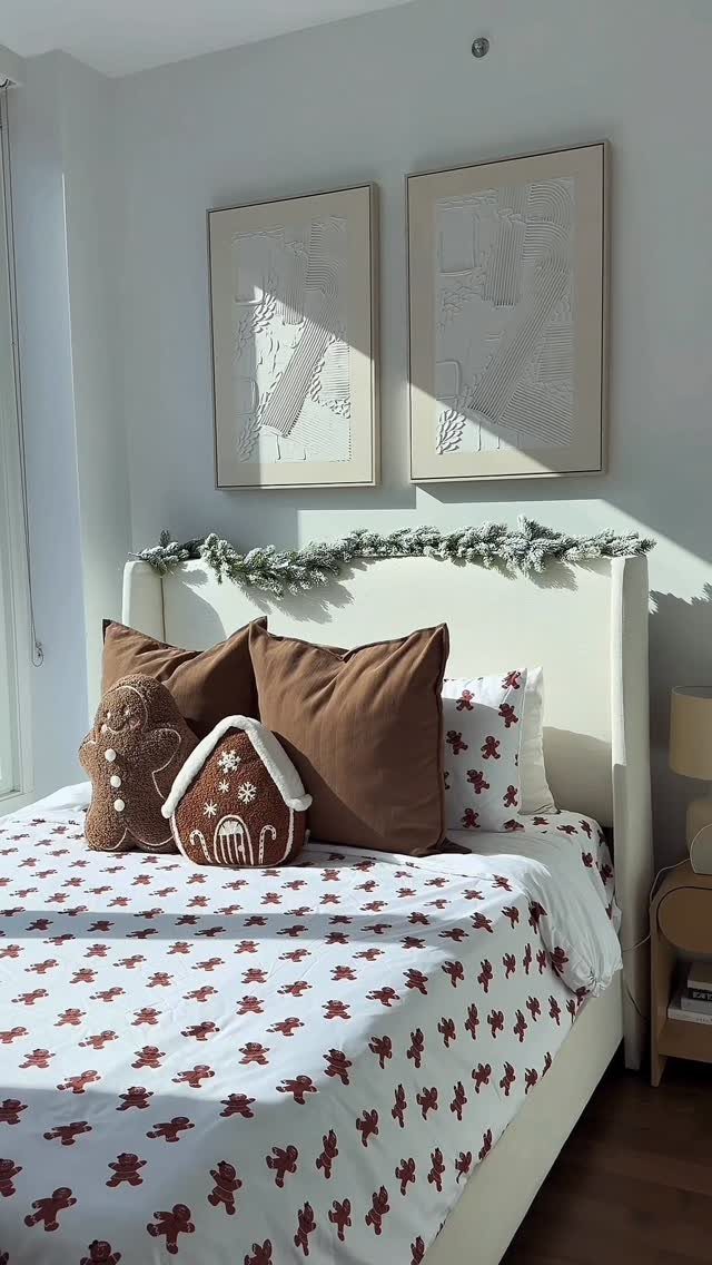 12 Studio Apartment Christmas Decor Ideas That Save Space 12 Bed with gingerbread cushions and festive garland decor in a bright studio apartment.