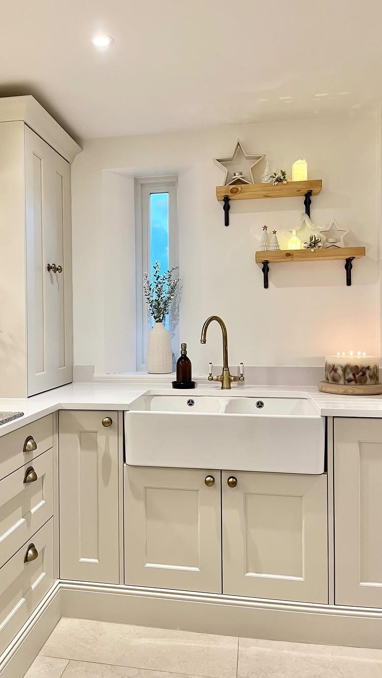 12 Studio Apartment Christmas Decor Ideas That Save Space 3 White kitchen with floating shelves decorated with white stars and glowing candles.