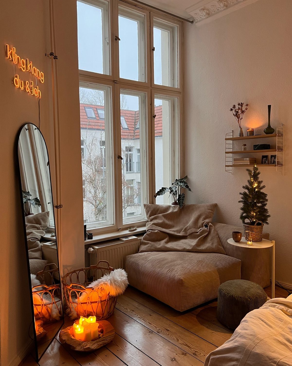 12 Studio Apartment Christmas Decor Ideas That Save Space 7 Small decorated Christmas tree on a side table in a cozy apartment corner.