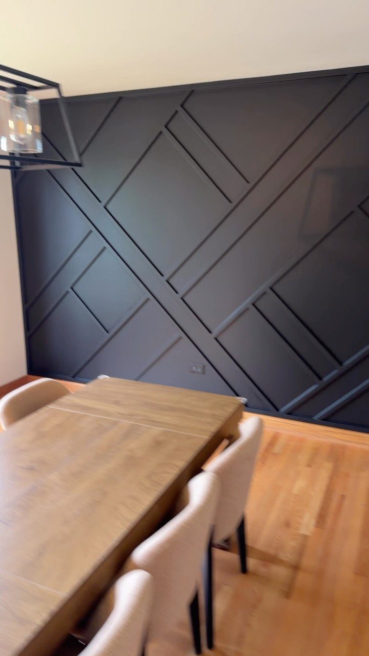 Traditional Modern Dining Room Ideas: 20 Ways to Blend Styles 6 Dark charcoal accent wall with geometric molding behind a wooden dining table and chairs
