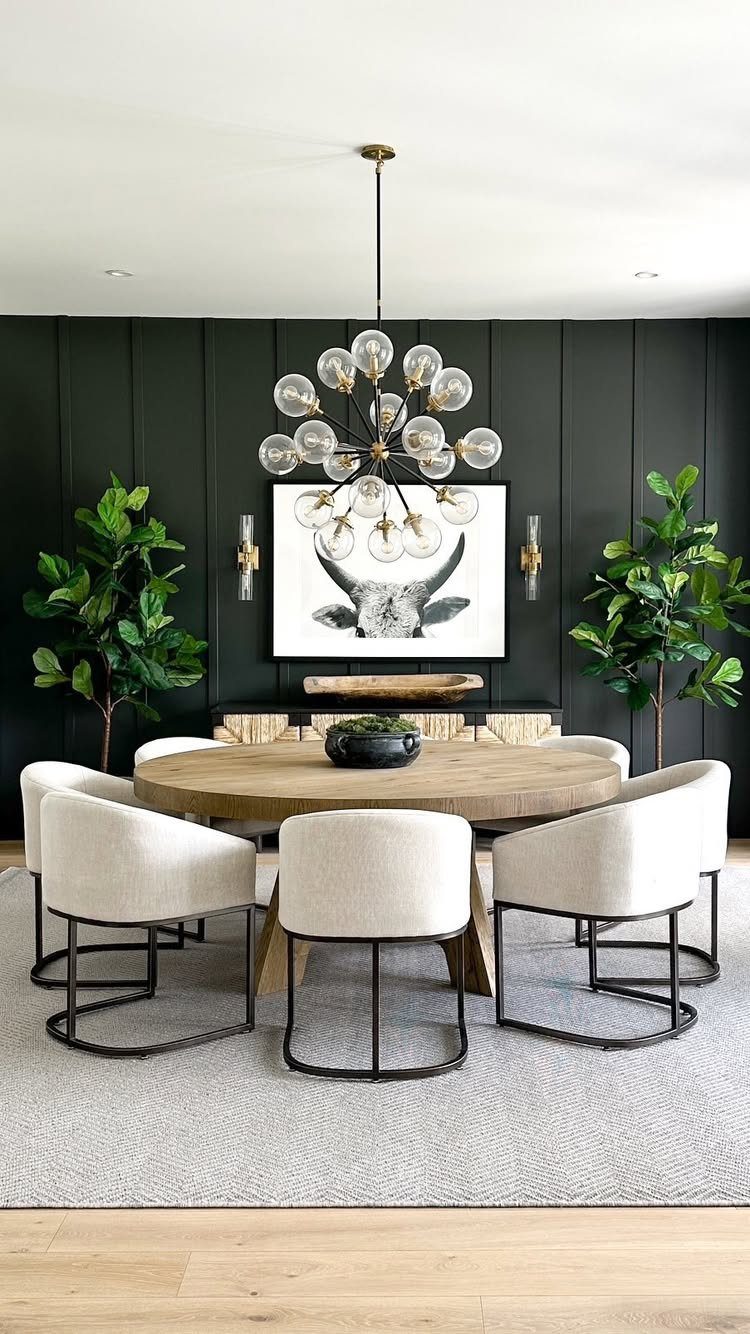 Traditional Modern Dining Room Ideas: 20 Ways to Blend Styles 20 Round wooden dining table with cream chairs and a modern chandelier against dark green walls.
