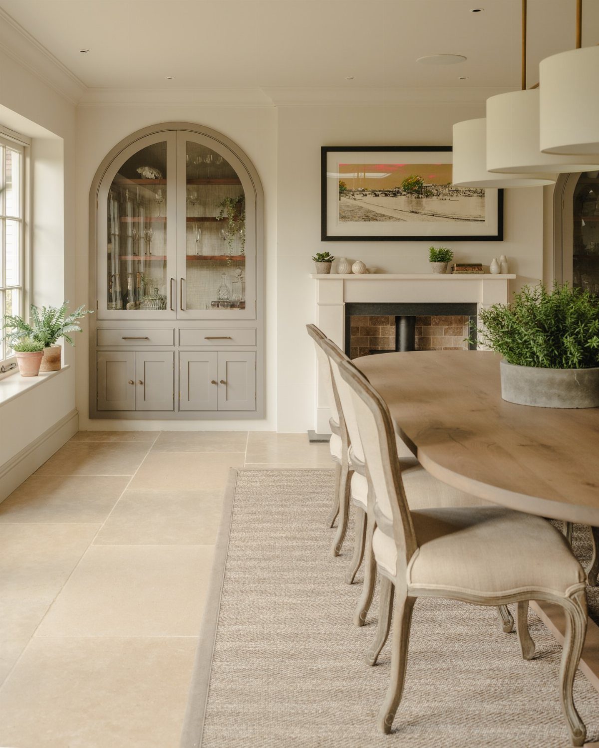 Traditional Modern Dining Room Ideas: 20 Ways to Blend Styles 16 Dining room with light wood table, upholstered chairs, and grey arched built-in cabinet.
