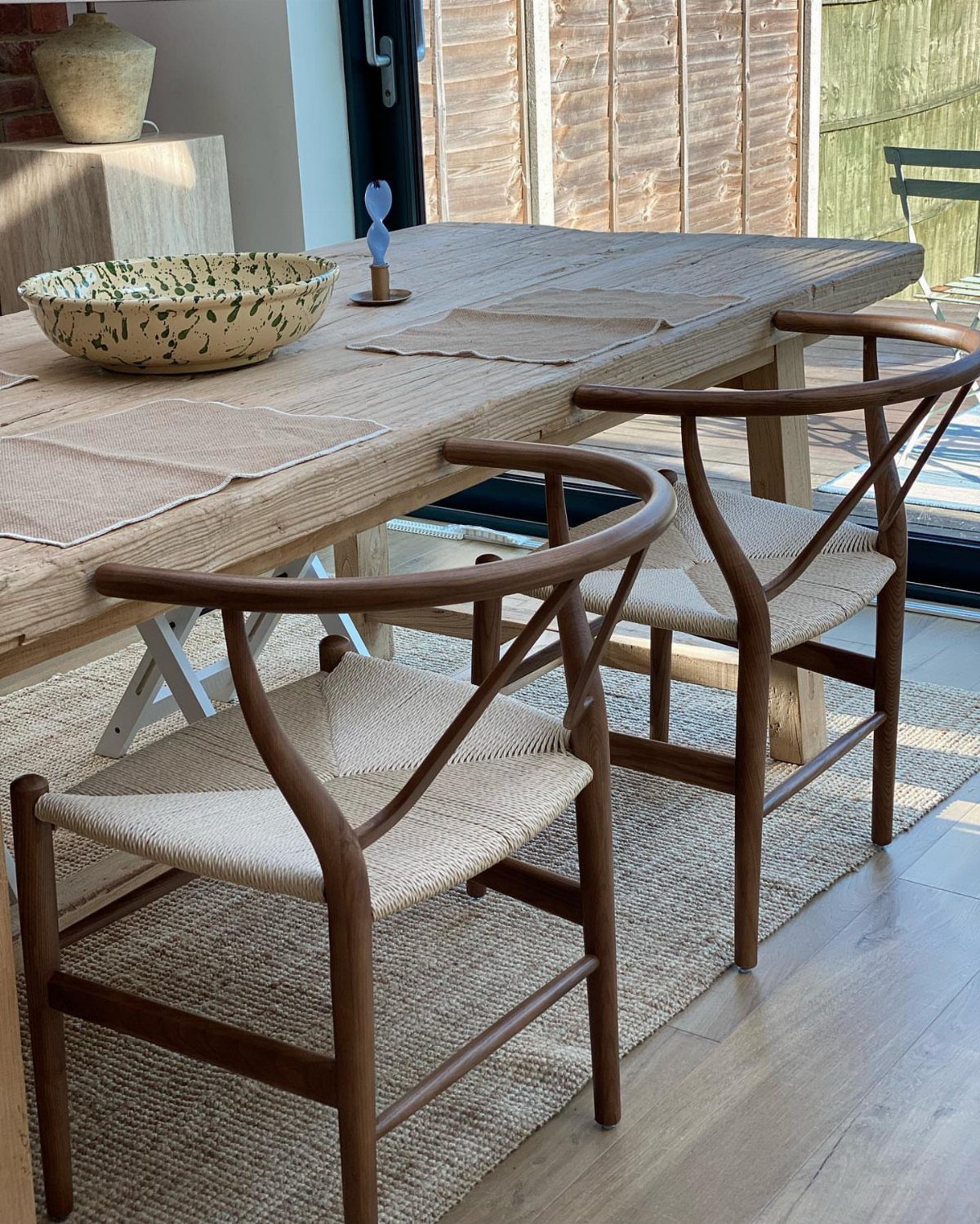 Traditional Modern Dining Room Ideas: 20 Ways to Blend Styles 19 Wooden dining table with woven placemats and Wishbone chairs on a neutral rug.
