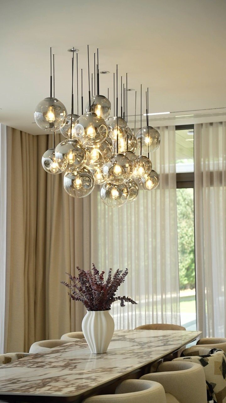 5 Transitional Dining Room Light Ideas for 2026 3 Cluster of glass globe pendant lights hanging over a marble dining table
