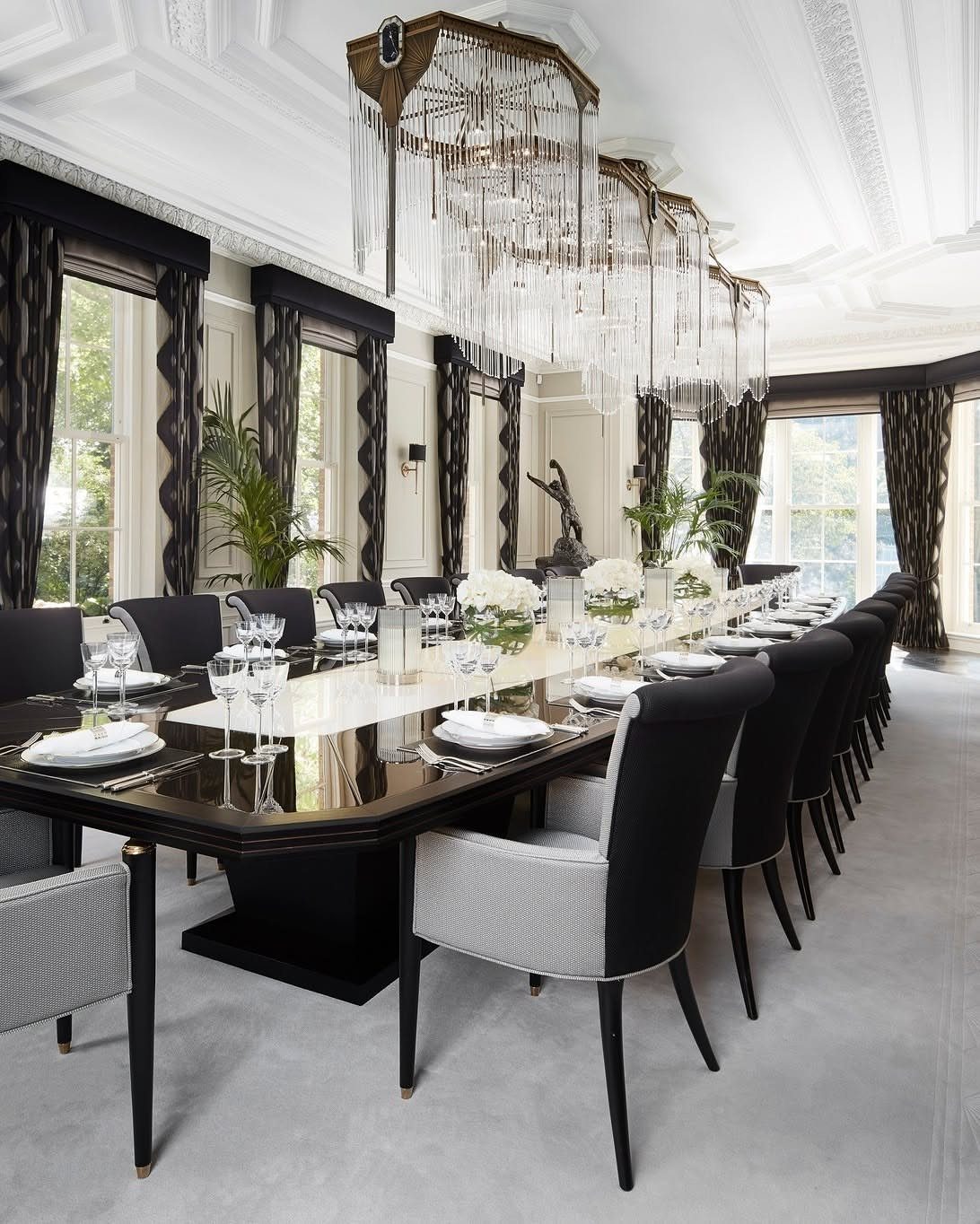 5 Transitional Dining Room Light Ideas for 2026 4 Three rectangular crystal chandeliers hanging over a long black and white dining table.