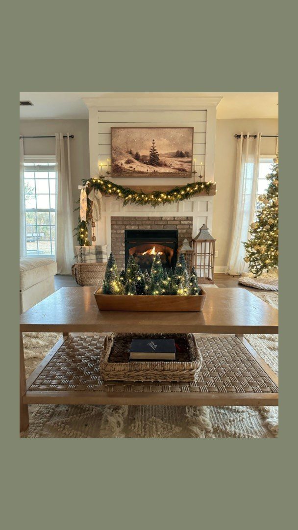 Living room with fireplace, garland lights, and bottle brush trees on coffee table