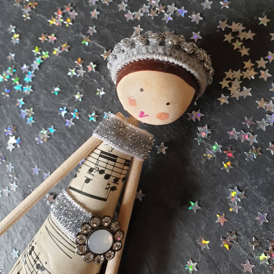 Handmade doll wearing a dress made from vintage sheet music and silver glitter.
