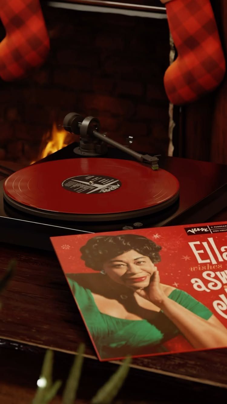 Red vinyl record on a turntable with Christmas stockings and a fireplace background