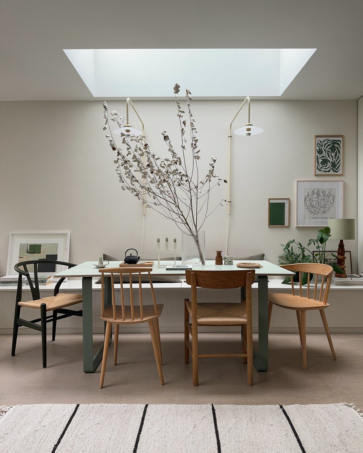 9 Wabi Sabi Dining Table Ideas for an Organic, Lived-In Space 7 Minimalist dining table with wooden chairs and a sparse branch in a bright room