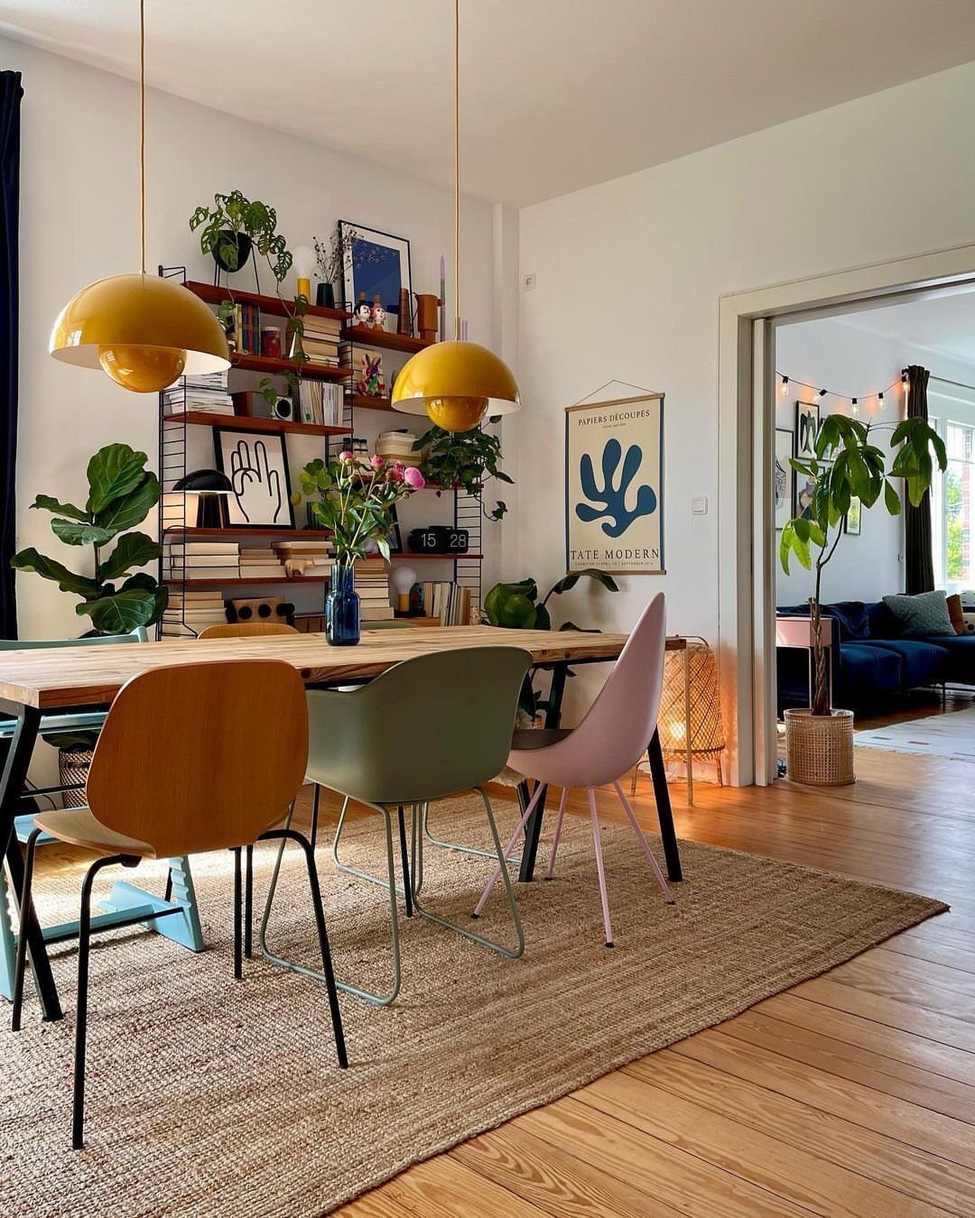 9 Wabi Sabi Dining Table Ideas for an Organic, Lived-In Space 2 Mismatched dining chairs in brown, green, and pink around a wooden table.