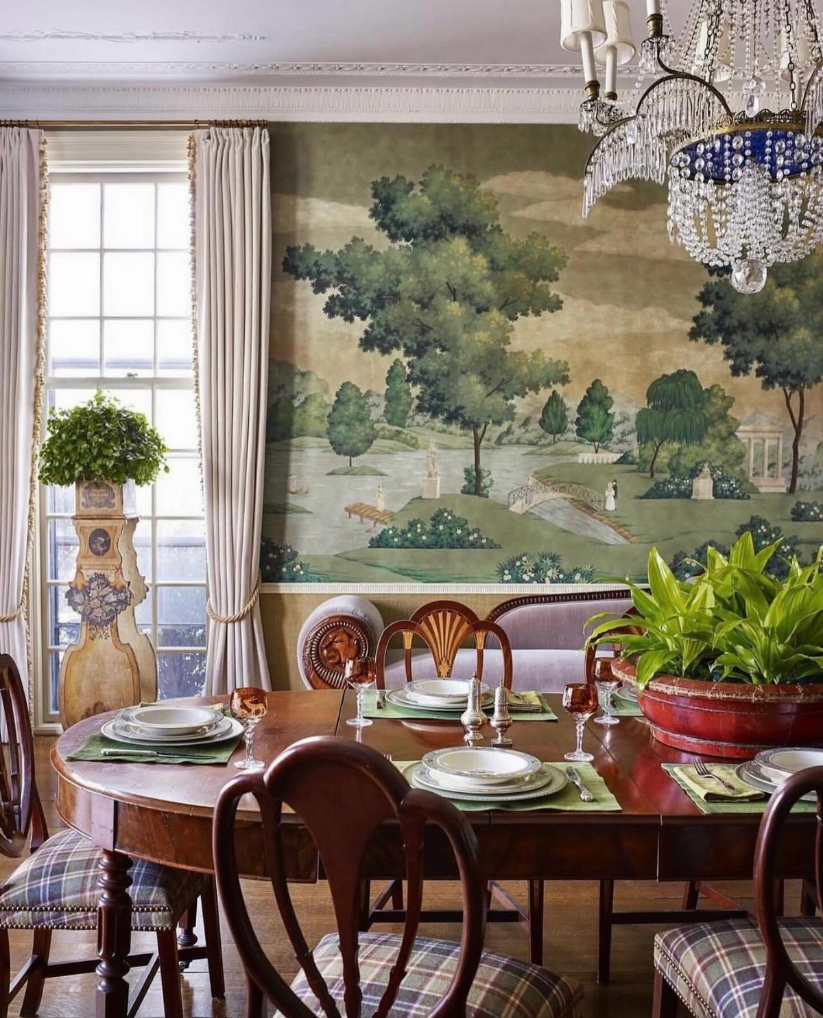 Traditional dining room with a large landscape wall mural and a crystal chandelier.